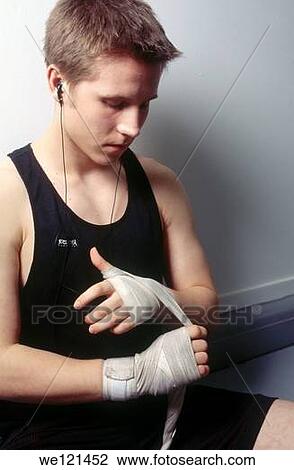 Stock Image - 15-17 year old boxer wrapping hands. Fotosearch