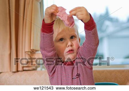 Stock Image - 2 year old boy playing with playdough. Fotosearch