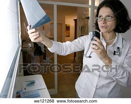 Female radiologist inspecting an X-ray image View Large Photo Image Stock Photo - Female radiologist inspecting an X-ray image. Fotosearch