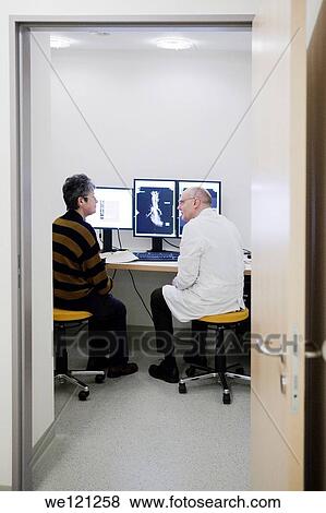 Stock Photo - Radiologist explaining patient, the result of the MRI scan. Fotosearch