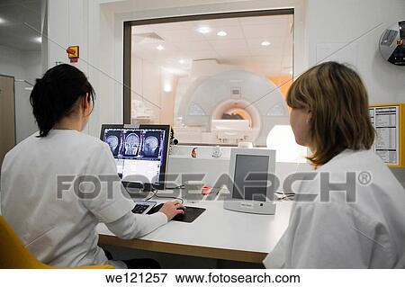 Stock Photo - Radiology technicians monitoring MRI scan in progress. Fotosearch