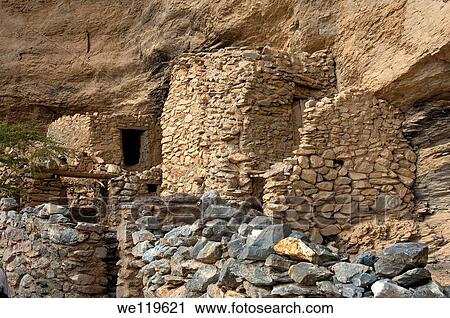 Stone huts of the deserted village of Sap Bani Khamis under a rock overhang in the Grand Canyon of Oman in Wadi an Nakhur, Jabal Akhdar mountains, Sultanate of Oman View Large Photo Image Stock Image - Stone huts of the deserted village of Sap Bani Khamis under a rock overhang in the Grand Canyon of Oman in Wadi an Nakhur, Jabal Akhdar mountains, Sultanate of Oman. Fotosearch