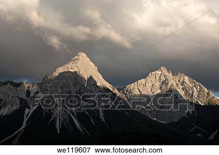 The peaks Ehrwalder Sonnenspitze and Gruenstein in the eerie light of an approaching thunderstorm, Mieminger mountain range, Ehrwald, Tyrol, Austria View Large Photo Image Stock Photo - The peaks Ehrwalder Sonnenspitze and Gruenstein in the eerie light of an approaching thunderstorm, Mieminger mountain range, Ehrwald, Tyrol, Austria. Fotosearch