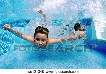 Stock Photo - Underwater photograph of two boys, aged 5 and 7 years old, jumping into swimming pool. Fotosearch