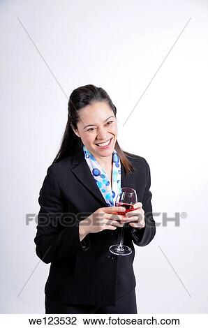 A young business woman holding a glass of wine She is of filipino ethnicity View Large Photo Image Stock Image - A young business woman holding a glass of wine She is of filipino ethnicity. Fotosearch