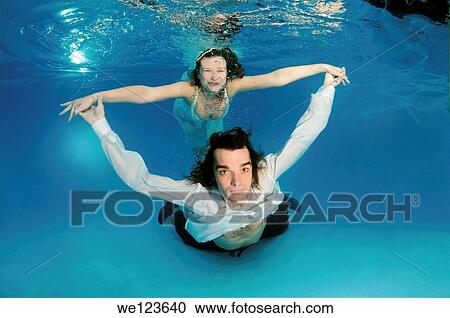 Stock Image - Bridal couple, underwater wedding in pool. Fotosearch