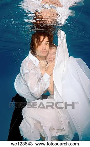 Stock Image - Bridal couple, underwater wedding in pool. Fotosearch