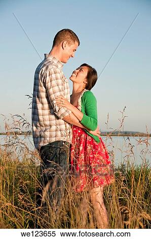 Standing in tall grass is a mixed race couple arm in arm. View Large Photo Image Stock Photography - Standing in tall grass is a mixed race couple arm in arm.. Fotosearch
