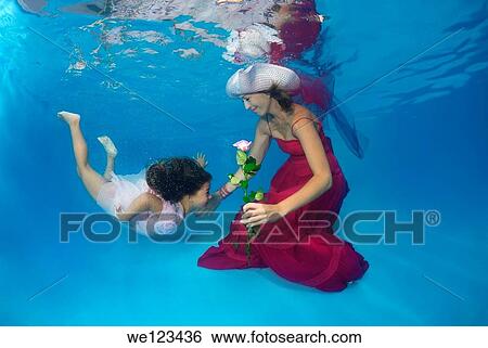 Woman and girl, underwater models, presenting fashion in pool View Large Photo Image Stock Photograph - Woman and girl, underwater models, presenting fashion in pool. Fotosearch