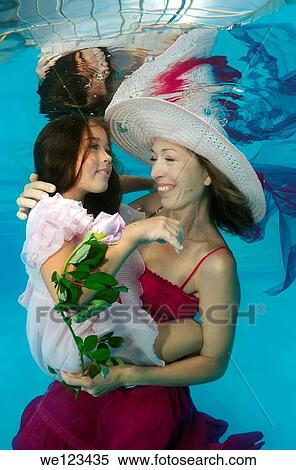 Woman and girl, underwater models, presenting fashion in pool View Large Photo Image Stock Photography - Woman and girl, underwater models, presenting fashion in pool. Fotosearch