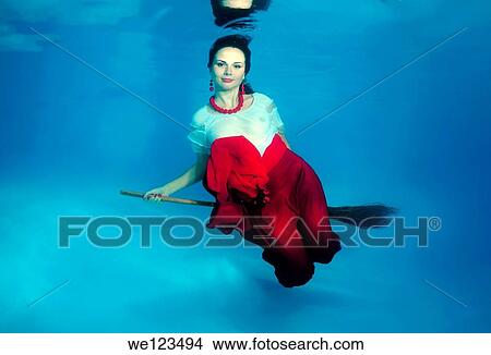 Picture - Woman presenting underwater fashion in a pool. Fotosearch