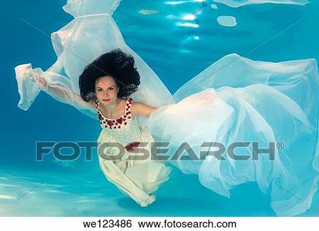 Woman presenting underwater fashion in a pool View Large Photo Image Stock Photograph - Woman presenting underwater fashion in a pool. Fotosearch