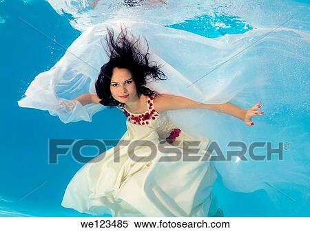 Stock Photography - Woman presenting underwater fashion in a pool. Fotosearch