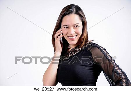 young woman talking on the telephone and is smiling She is of mixed ethnicity View Large Photo Image Stock Photo - young woman talking on the telephone and is smiling She is of mixed ethnicity. Fotosearch