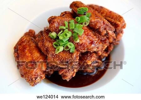 Picture - Barbecued chicken wings with sauce.. Fotosearch