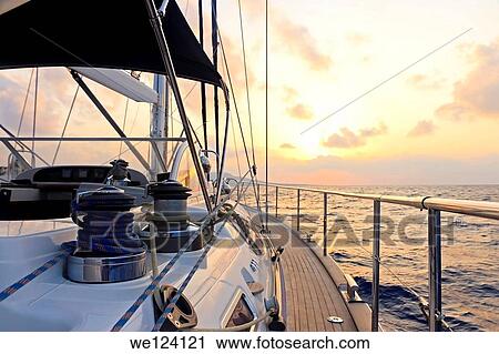 Stock Image - Yacht sailing at sunset along Akamas peninsula, Cyprus.. Fotosearch