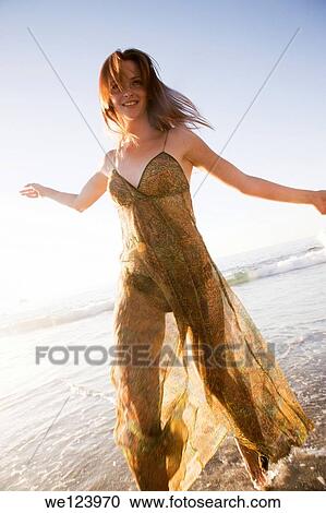 Stock Image - Young Woman Celebrating On Beach.. Fotosearch
