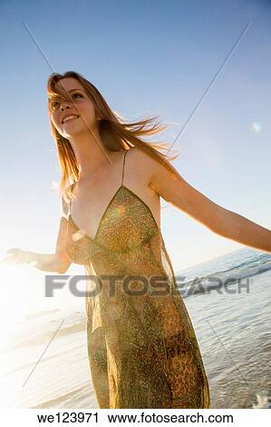 Stock Image - Young Woman Celebrating On Beach.. Fotosearch