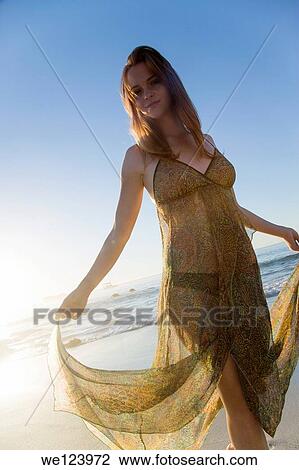 Stock Image - Young Woman Celebrating On Beach.. Fotosearch
