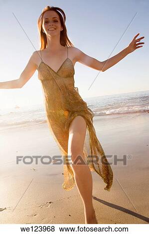 Stock Photo - Young Woman Celebrating On Beach.. Fotosearch