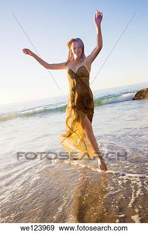 Stock Photo - Young Woman Celebrating On Beach.. Fotosearch