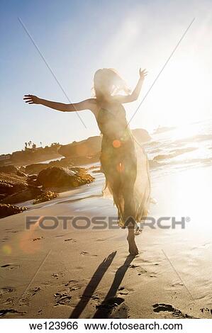 Stock Photograph - Young Woman Celebrating On Beach.. Fotosearch