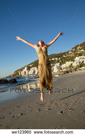 Stock Photography - Young Woman Celebrating On Beach.. Fotosearch