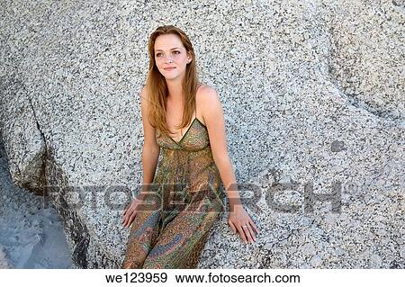 Stock Photo - Young Woman On Beach Against Rock.. Fotosearch