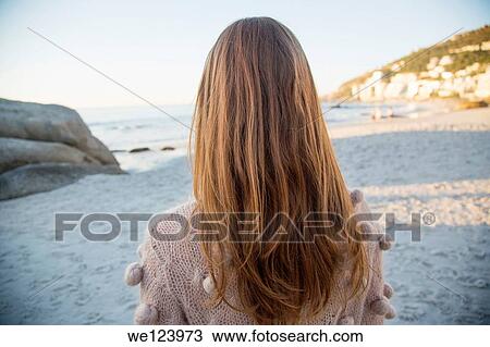 Stock Image - Young Woman Sat On Beach.. Fotosearch