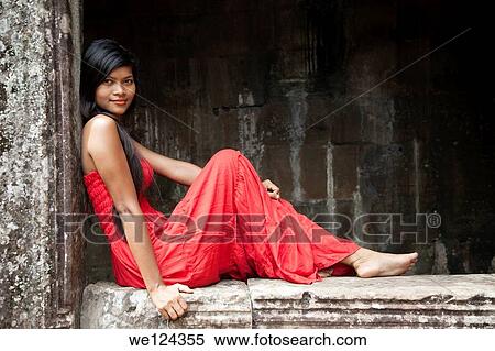 Beautiful Cambodian woman wearing a red dress posing at Bayon temple in Angkor Thom Cambodia. View Large Photo Image Stock Photography - Beautiful Cambodian woman wearing a red dress posing at Bayon temple in Angkor Thom Cambodia.. Fotosearch