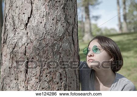 Eurasian teenage girl at a park wearing green sunglasses. View Large Photo Image Stock Photograph - Eurasian teenage girl at a park wearing green sunglasses.. Fotosearch