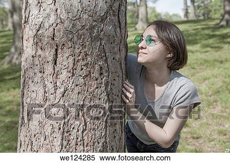 Stock Photography - Eurasian teenage girl at a park wearing green sunglasses.. Fotosearch