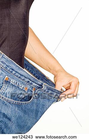 Trying jeans pants after strong diet isolated on white background. View Large Photo Image Stock Image - Trying jeans pants after strong diet isolated on white background.. Fotosearch