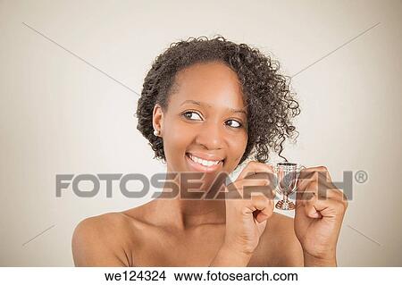 Young black woman holding a very small trophy cup. View Large Photo Image Picture - Young black woman holding a very small trophy cup.. Fotosearch