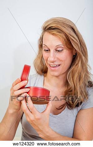 Young woman looking inside a round red container. View Large Photo Image Stock Image - Young woman looking inside a round red container.. Fotosearch