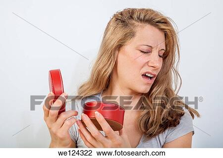 Young woman looking inside a round red container. View Large Photo Image Stock Image - Young woman looking inside a round red container.. Fotosearch
