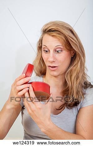 Young woman looking inside a round red container. View Large Photo Image Stock Photo - Young woman looking inside a round red container.. Fotosearch