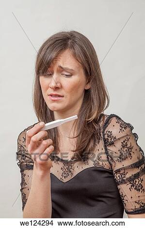Young woman with a pregnancy tester. View Large Photo Image Picture - Young woman with a pregnancy tester.. Fotosearch