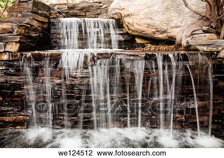 Stock Image - A small man made waterfall in the garden of the Fairmont Hotel in Santa Monica.. Fotosearch