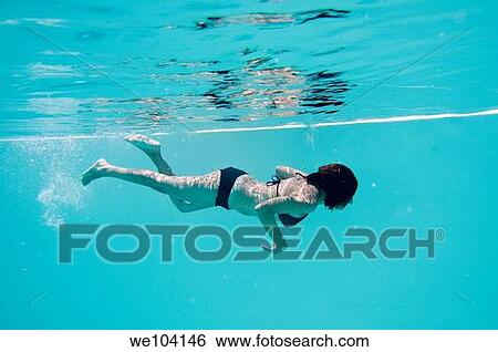 Stock Photograph - A woman swimming underwater. Fotosearch