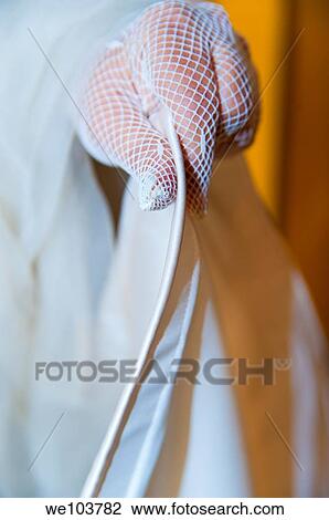 Bride wearing satin wedding gloves holding dress View Large Photo Image Stock Image - Bride wearing satin wedding gloves holding dress. Fotosearch