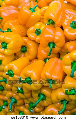 Stock Image - Bright yellow peppers piled up. Fotosearch