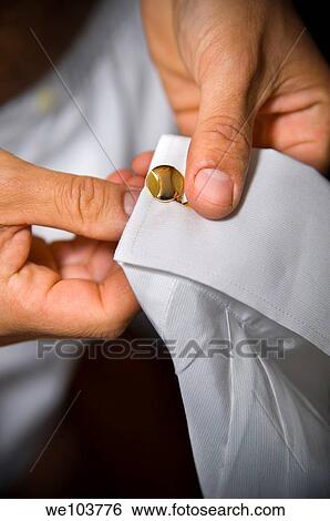 Stock Photograph - Close up Man putting on cufflinks. Fotosearch