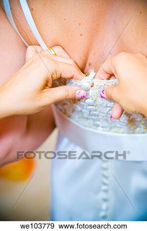 Close-up of woman helping by buttoning up a wedding dress View Large Photo Image Stock Photo - Close-up of woman helping by buttoning up a wedding dress. Fotosearch