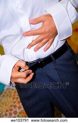 Cropped view of man putting on a belt View Large Photo Image Stock Image - Cropped view of man putting on a belt. Fotosearch