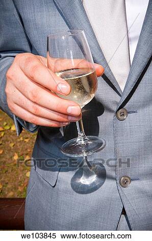 Stock Photography - Man holding a glass of white wine. Fotosearch