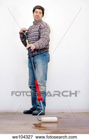Operator applying varnish to a parquet floor with a paint roller View Large Photo Image Stock Photo - Operator applying varnish to a parquet floor with a paint roller. Fotosearch