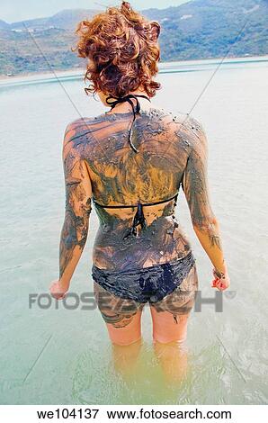 Rear view of woman covered in mud standing in lake, Lago Specchio di Venere, island of Pantelleria, Sicily, Italy View Large Photo Image Stock Photo - Rear view of woman covered in mud standing in lake, Lago Specchio di Venere, island of Pantelleria, Sicily, Italy. Fotosearch