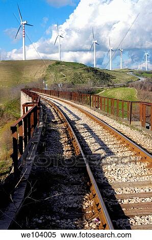 Train tracks and a distant road leading to a wind power farm View Large Photo Image Stock Photography - Train tracks and a distant road leading to a wind power farm. Fotosearch