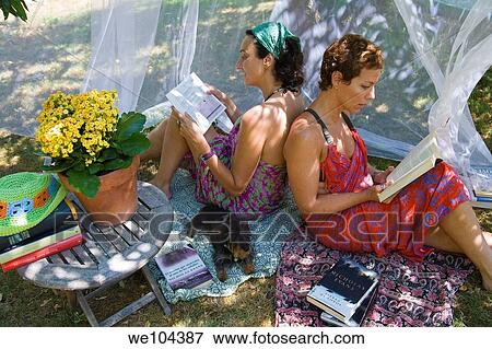 two young women reading in a garden View Large Photo Image Stock Photo - two young women reading in a garden. Fotosearch